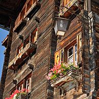 House front of traditional wooden house / chalet decorated with old skis in the Alpine village Grimentz, Valais, Switzerland